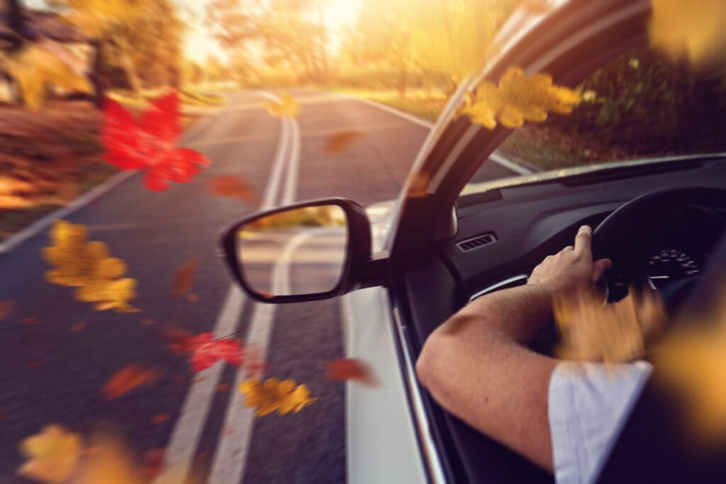 A man driving a car very fast during the autumn season in Houston Heights, TX
